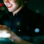 Uomo che gioca d'azzardo online su un cellulare